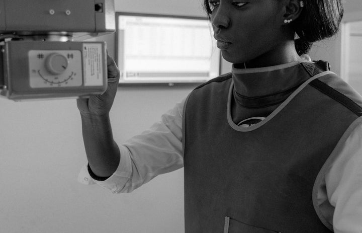 Technician operating an X-ray machine wearing protective gear