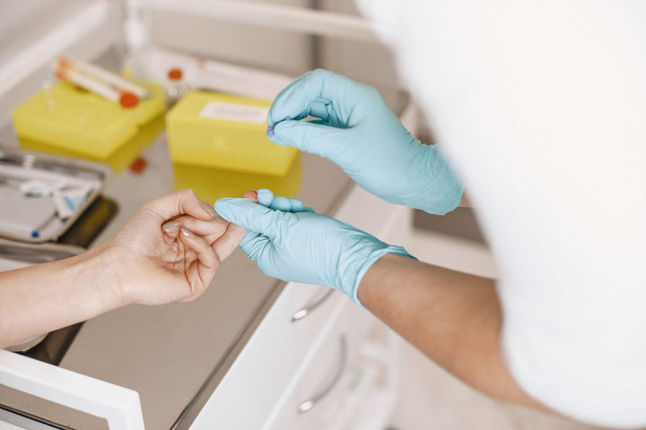 Healthcare professional wearing gloves taking a blood sample