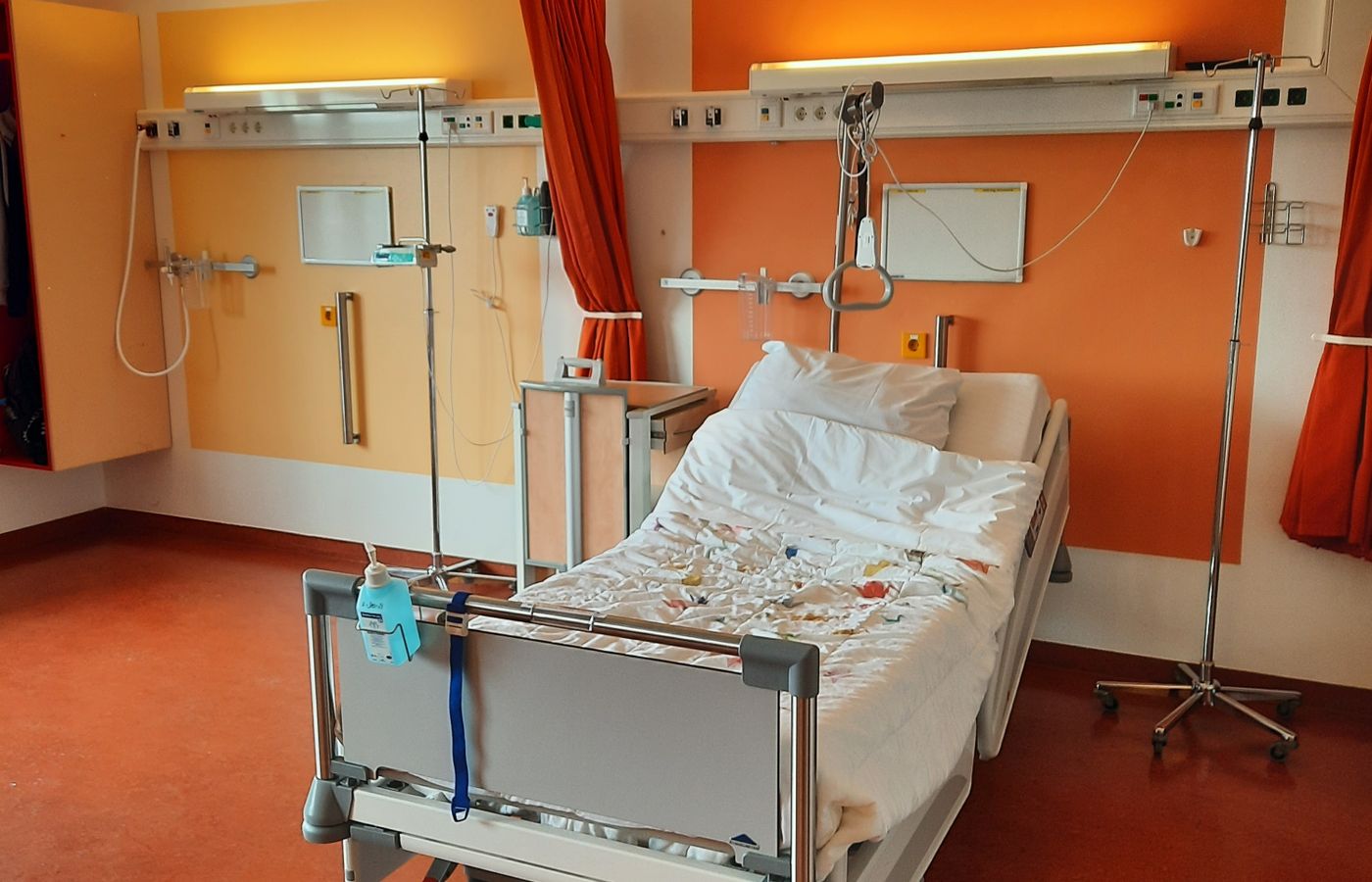 Adjustable hospital bed and equipment in a modern patient room