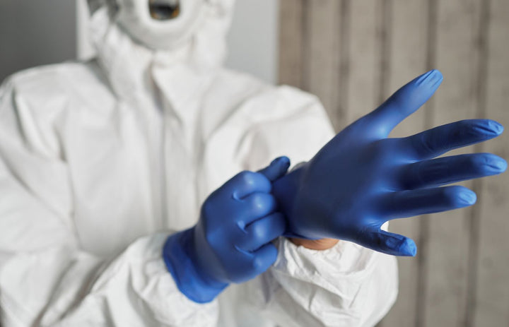 Healthcare worker in PPE wearing protective latex gloves