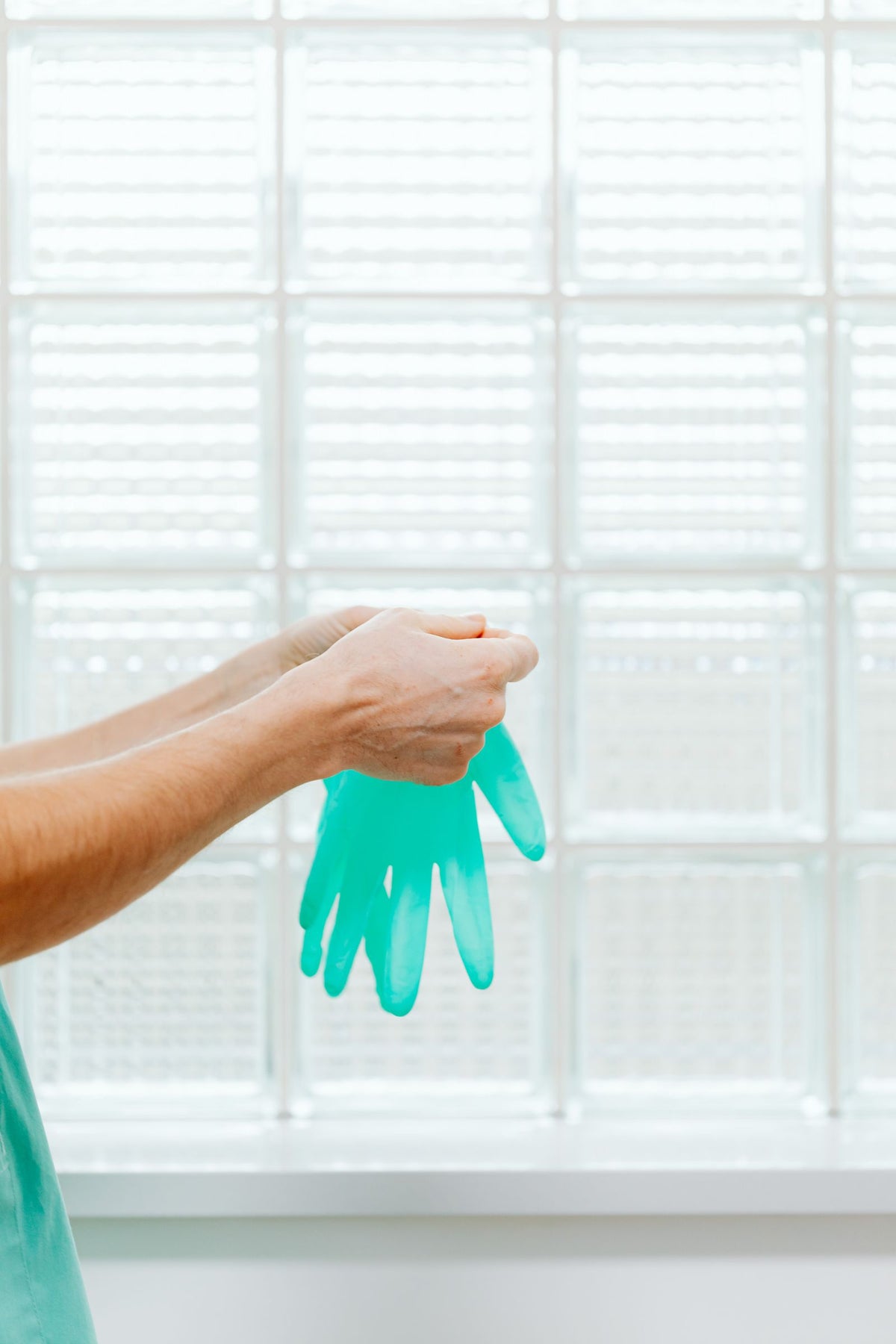 Clinician donning disposable exam gloves