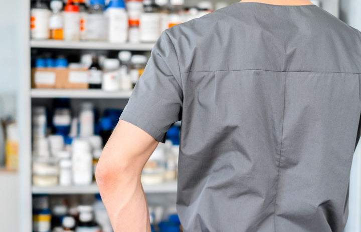 Pharmacist in cap and gloves organizing medication shelves